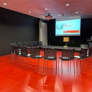 Grosser Raum mit Stühlen, Projektor und Leinwand..