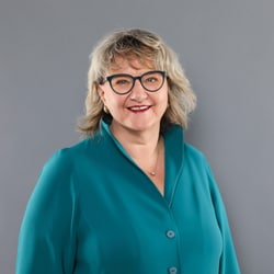 Romana Heuberger vor grauem Hintergrund
