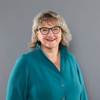 Romana Heuberger vor grauem Hintergrund