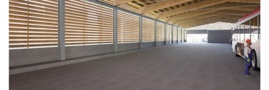 Neue Abstellhalle mit Holzdecke, Bus an der Seite und eine Person in Arbeitskleidung.