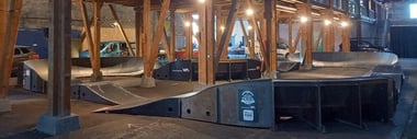 Innenansicht einer Halle mit Holzstruktur und Rampen.