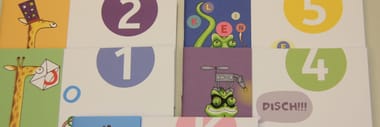 Bunte Hefte mit Giraffen und Comic-Illustrationen.