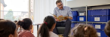 Kaspar Bopp liest einer Gruppe von Kindern ein Buch vor.