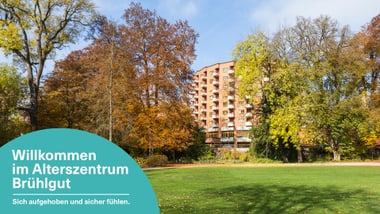Gebäude im Herbst von Bäumen umgeben mit Beschriftung.