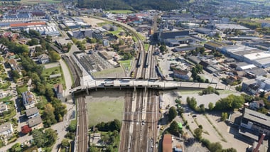 Luftaufnahme einer Stadt mit Bahngleisen und Gebäuden.