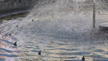 Springbrunnen mit Wasserstrahlen im Licht.