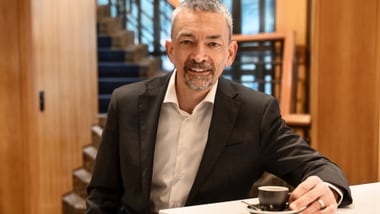 Mann mit Anzug sitzt mit Espresso an einem Tisch in der ZKB am Untertor.