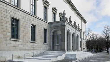 Historisches Gebäude mit Skulpturen und grossem Eingang.