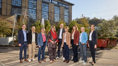 Gruppe von Menschen steht vor einem Gebäude mit der Aufschrift Skills Park.
