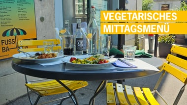 Gelber Tisch und Stühle mit Essen und Getränken draussen.