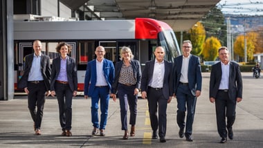 Die Geschäftsleitung von Stadtbus posiert vor einem Bus.