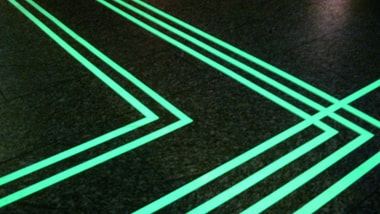 Leuchtende grüne Linien auf dunklem Boden.