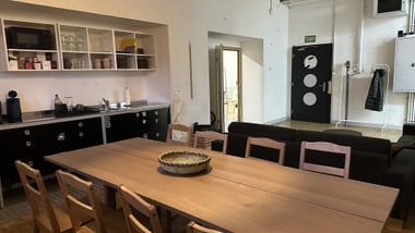 Essbereich mit Holztisch und Küchenzeile.