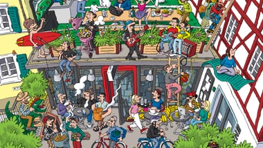 Viele Menschen bei einer lauten Party in einem Gebäude mit Balkon und Hof.