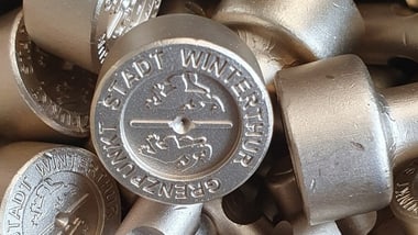 Nahaufnahme von Metallstempeln mit geprägtem Emblem.