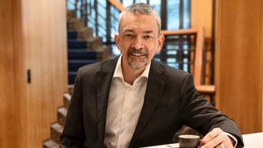 Mann mit Anzug sitzt mit Espresso an einem Tisch in der ZKB am Untertor.
