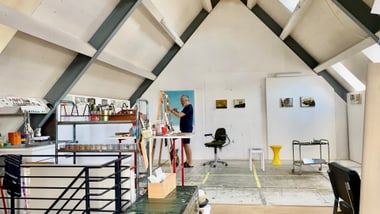 Künstleratelier mit einer Person, die malt.