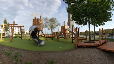 Spielplatz mit Holzklettergerüst und Rutsche beim Schulhaus Zinzikon