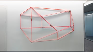 Geometrische rote Wandkunst in modernem Innenraum.