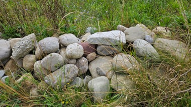 Steinhaufen im grasbewachsenen Feld.