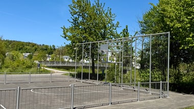 Leerer eingezäunter Basketballplatz im Freien.