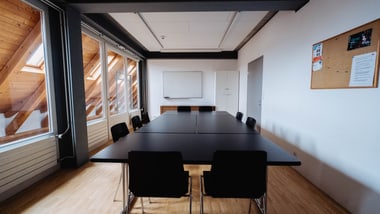 Leerer Konferenzraum mit Tisch und Stühlen.