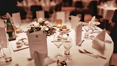 Eleganter gedeckter Tisch mit Blumen und Menükarten.