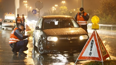 Auto bei regnerischem Wetter an einer Verkehrskontrolle.