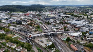 Luftaufnahme einer Stadt mit Gleisen und Gebäuden.