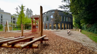 Spielplatz mit Holzklettergerüsten neben dem ehemaligen Swica-Gebäude