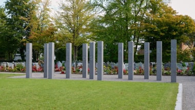Hohe Steinpfeiler auf einer grünen Wiese.
