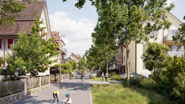 Kinder malen auf einer Strasse mit Häusern und Bäumen.