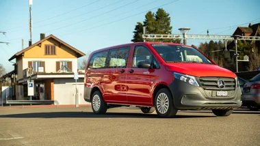 Roter Mobility Van auf einem Parkplatz bei sonnigem Wetter.