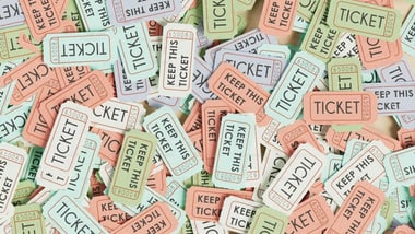 Mehrere Tickets in verschiedenen Farben übereinander gestapelt.