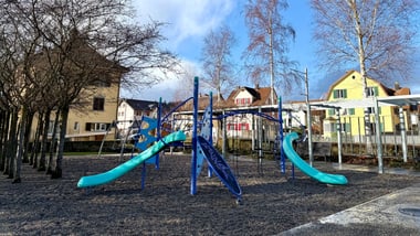 Spielplatz Juchpark mit Rutschen und Bäumen im Hintergrund.