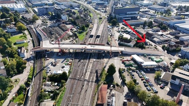 Luftaufnahme einer Stadt mit Bahngleisen und Strassen.