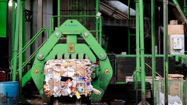 Maschine verarbeitet gepresstes Altpapier in einer Recyclinganlage.