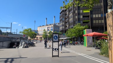 Städtische Strasse mit Fussgängern und modernen Gebäuden.