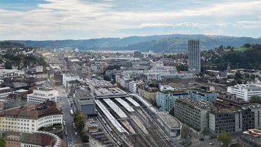 Luftaufnahme einer Stadt mit Bahnhofsgebäuden und Schienen.