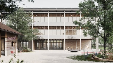 Moderne Gebäude mit Glasfassade, umgeben von Bäumen.