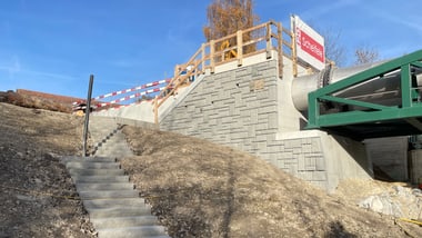 Treppenaufgang neben einer Betonwand.