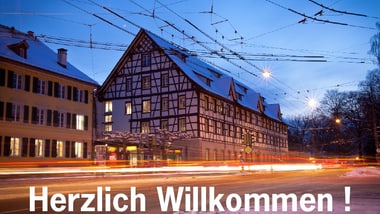 Nachtszene einer beleuchteten Fachwerkhalle mit Schneebedeckung.