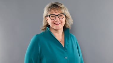 Romana Heuberger vor grauem Hintergrund