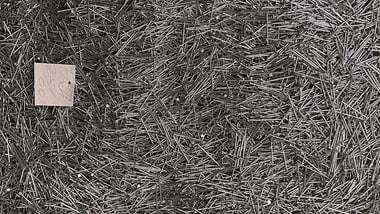 Ein Haufen aus Metallstäben mit einem kleinen weissen Quadrat.