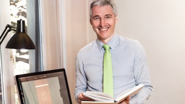 Grafiker mit Buch in seinem Büro