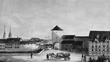 Historische Stadtansicht mit Tor, Pferdekutsche und Gebäuden.