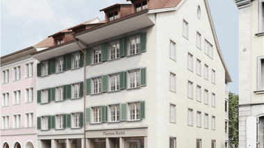 Mehrstöckiges Gebäude mit grünen Fensterläden.