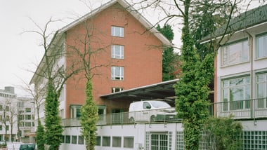 Rotes Backsteingebäude mit Lieferwagen auf dem Balkon geparkt.
