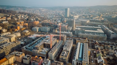 Luftaufnahme einer Stadt mit Gebäuden und Baukran.