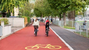 Zwei Personen fahren auf der Veloroute Wülflingen neben dem Sportplatz Schützenwiese